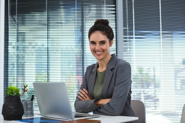 Confident female executive sitting at desk — Stock Photo, Image