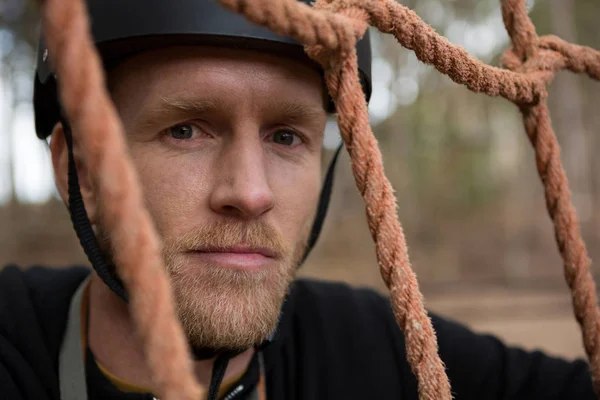 Man posing through rope fence — Stock Photo, Image