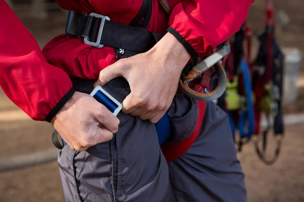 Hiker man adjusting his harness — Stock Photo, Image