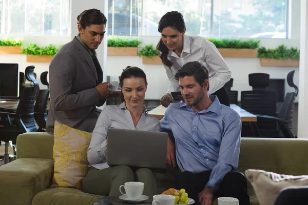 Grupp av executive diskuterar över laptop — Stockfoto