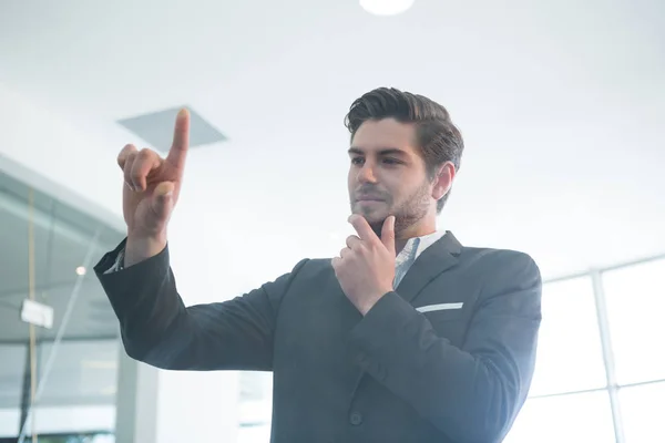 Pensativo hombre de negocios tocando pantalla invisible — Foto de Stock