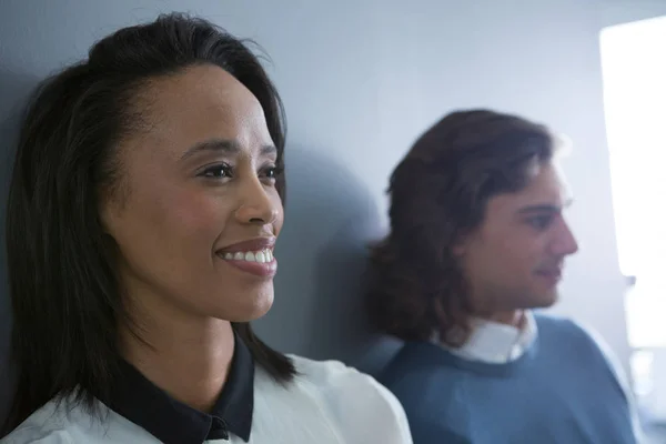 Male and female executives standing in office — Stock Photo, Image