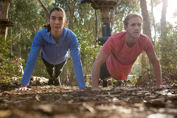 Kvinna och man gör push ups — Stockfoto