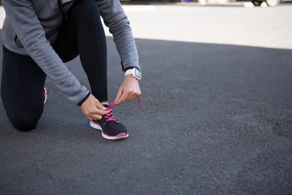 Kadın jogger onun ayakkabı bağcıklarımı bağlama — Stok fotoğraf