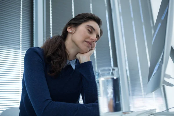 Vrouwelijke uitvoerend ontspannen aan balie — Stockfoto