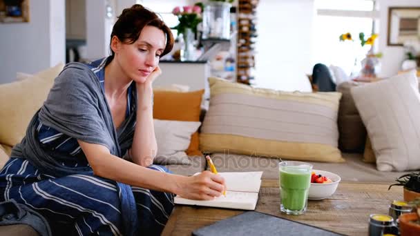 Jonge Vrouw Schrijven Notitie Boek Ontbijt Tafel Streelde Baby Thuis — Stockvideo