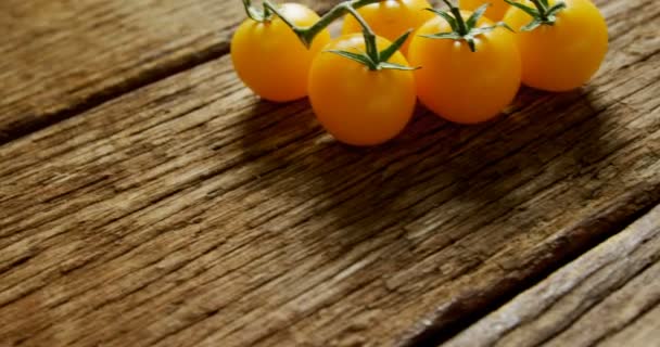 Close Tomates Cereja Amarelos Com Caule Chão Madeira — Vídeo de Stock