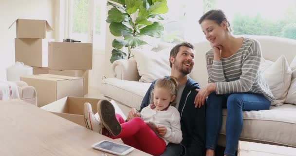 幸福的家庭坐在和使用平板电脑在他们的新家4K — 图库视频影像