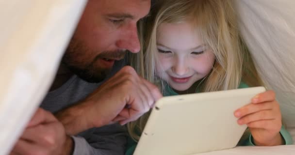 タブレットを使用して毛布で覆われて幸せな父と娘のクローズ アップ — ストック動画