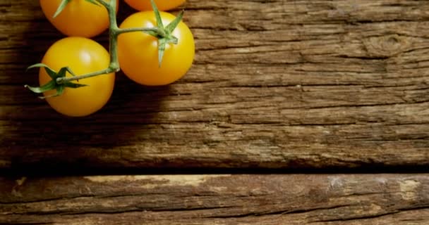 Close Tomates Cereja Amarelos Com Caule Chão Madeira — Vídeo de Stock