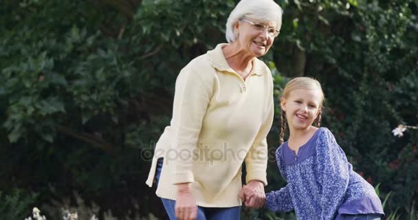 Mormor Påpeka Något För Liten Flicka Och Skrattar Trädgården — Stockvideo