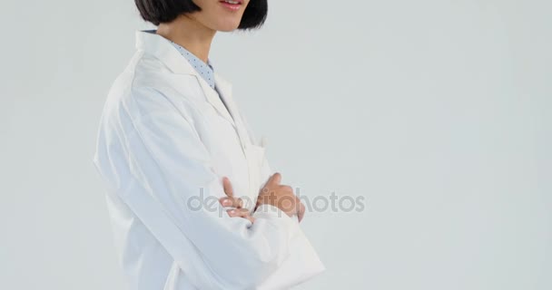 腕を組んで の白い背景に対して立っている女性医師の肖像画 — ストック動画