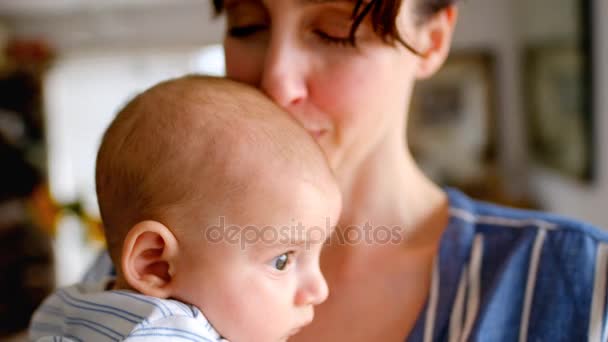 亲密的年轻妈妈抱着她的宝宝在家里亲吻4K — 图库视频影像