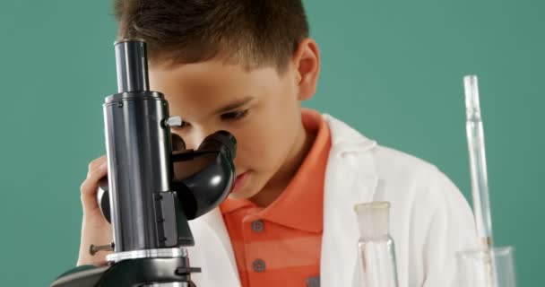 Школьник Смотрит Через Микроскоп Лаборатории Бирюзовом Фоне — стоковое видео