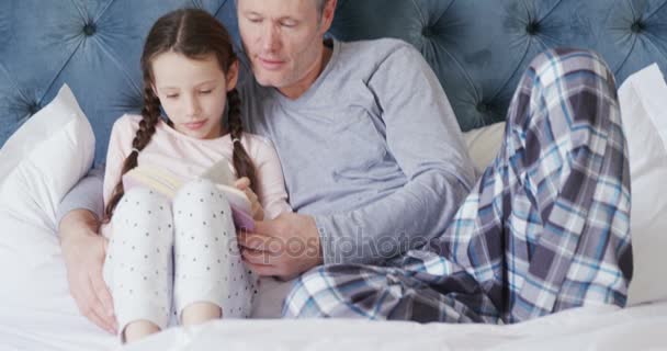 Πατέρας Και Κόρη Διαβάζοντας Ένα Βιβλίο Μαζί Στην Κρεβατοκάμαρα — Αρχείο Βίντεο