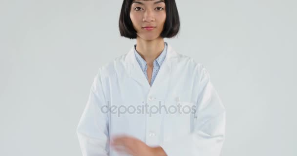 腕を組んで の白い背景に対して立っている女性医師の肖像画 — ストック動画