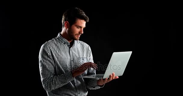 Sorrindo Homem Usando Laptop Contra Fundo Preto — Vídeo de Stock