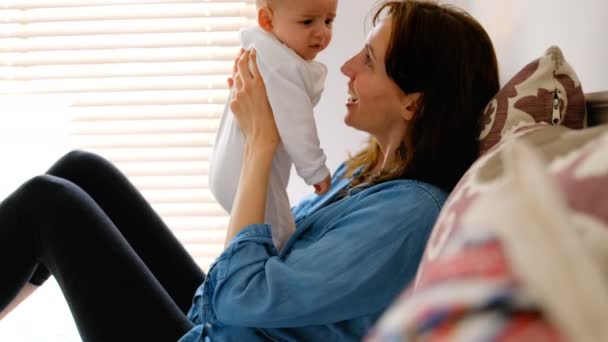 Young Mother Sitting Bed Kissing Her Crying Baby Bedroom Home — Stock Video