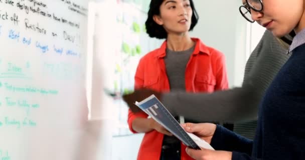 Weibliche Führungskraft Schaut Sich Dokument Während Kollegen Über Whiteboard Büro — Stockvideo