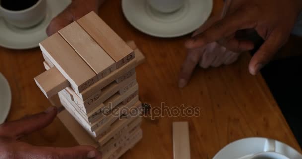 Seção Intermediária Amigos Jogando Jenga Jogo Mesa Enquanto Toma Café — Vídeo de Stock