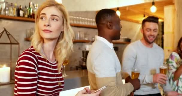 Jonge Vrouw Met Behulp Van Mobiele Telefoon Terwijl Vrienden Hebben — Stockvideo