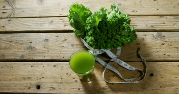 Grüner Tee Mit Blattgemüse Und Maßband Auf Holztisch — Stockvideo