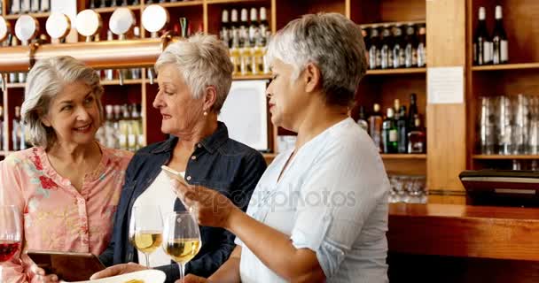 バーでワインをしながら携帯電話を使用しての年長の友人 — ストック動画
