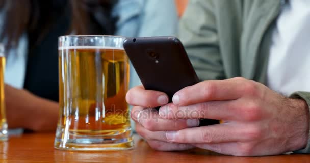 Seção Intermediária Amigos Usando Telefone Celular Enquanto Bebe Cerveja Bar — Vídeo de Stock