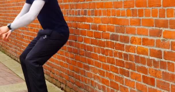 レンガの壁 に対して行使若い男 — ストック動画
