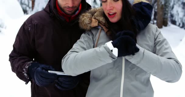Szczęśliwa Para Pomocą Zegarka Smartwatch Telefonu Komórkowego Podczas Zimowych — Wideo stockowe