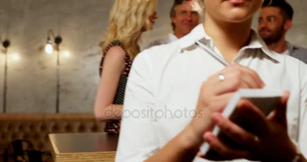 女服务生的肖像微笑 而朋友在酒吧喝酒4K — 图库视频影像