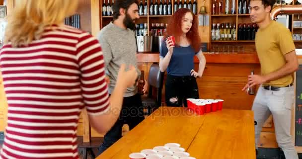バーでテーブルの上のビール ピンポンに遊んでいる友人のグループ — ストック動画