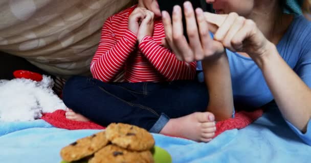 微笑的母亲和女儿在家里使用手机4K — 图库视频影像