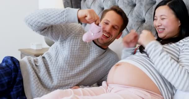 Mann Legt Babyschuhe Auf Frauenbauch Schlafzimmer Hause — Stockvideo