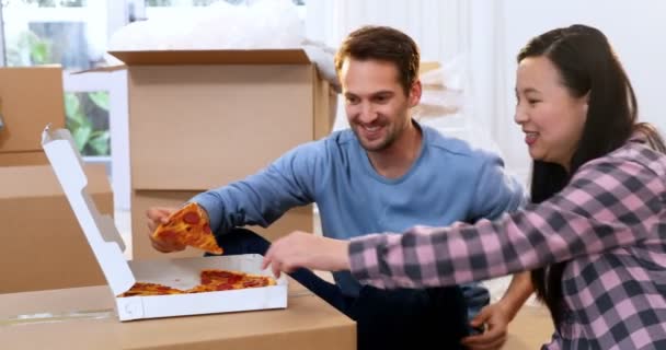 の新しい家でピザを持っている笑顔のカップル — ストック動画