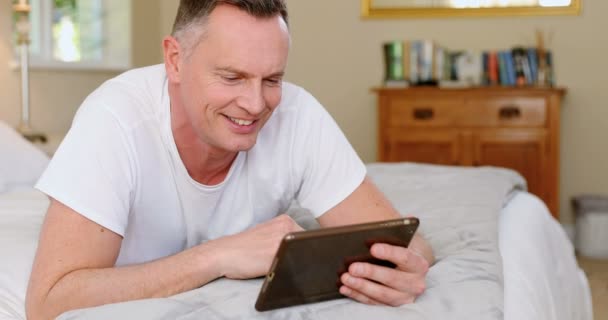 Man Met Digitale Tablet Terwijl Ontspant Bed Slaapkamer — Stockvideo