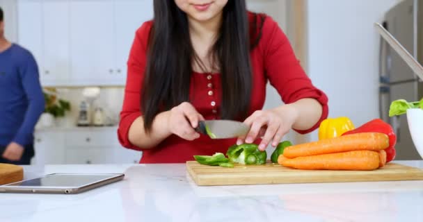 Mulher Sorridente Cortando Vegetais Enquanto Interage Com Homem Cozinha — Vídeo de Stock