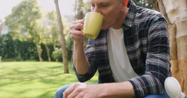在阳光明媚的日子里喝咖啡的成熟男人4K — 图库视频影像
