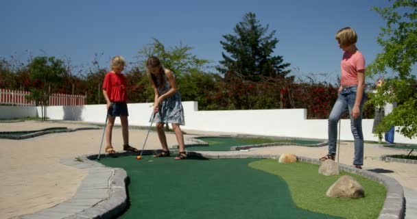 Crianças Jogando Golfe Miniatura Jardim Dia Ensolarado — Vídeo de Stock