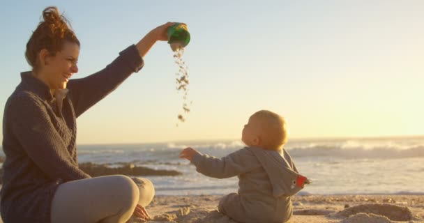 母亲在日落时分和她的小男孩在海滩玩耍4K — 图库视频影像
