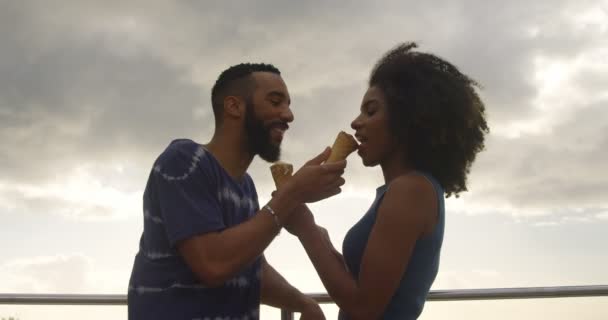 ロマンチックなカップルは のビーチでアイス クリーム コーンを食べる — ストック動画