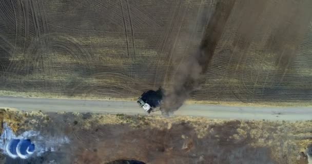 の晴れた日に収穫されたフィールド上を移動するトラクターの航空写真 — ストック動画