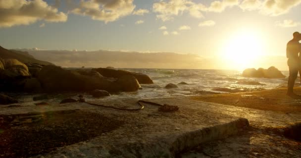 Ζευγάρι Στέκεται Μαζί Στην Παραλία Στο Σούρουπο — Αρχείο Βίντεο