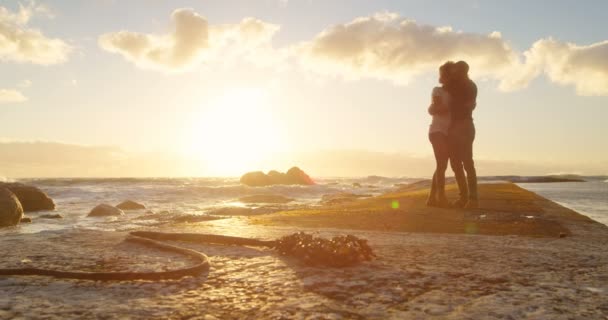 情侣在黄昏时分拥抱在海滩上4K — 图库视频影像