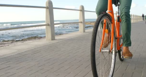 年轻人骑自行车在海滩4K — 图库视频影像