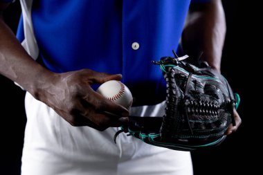 Front view mid section of an African American male baseball player, a pitcher, wearing a team uniform and a mitt, holding a baseball clipart