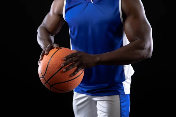 フロントビュー中央部の筋肉アフリカ系アメリカ人男性バスケットボール選手2手でバスケットボールを保持チーム色を身に着けている — ストック写真