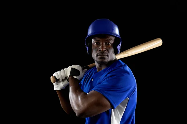 一个身穿队服 头戴安全帽 准备挥动棒球棒的非裔美国男性棒球运动员的画像 — 图库照片