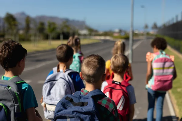 Rear View Diverse Group Schoolchildren Walking Road Elementary School Together — 스톡 사진