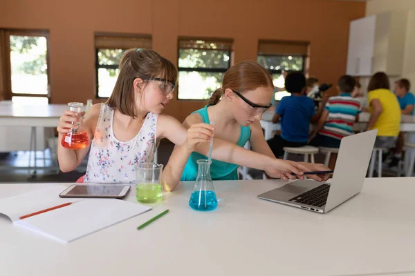 Front View Two Caucasian Schoolgirls Sitting Desk Wearing Safety Glasses — Stock Photo, Image